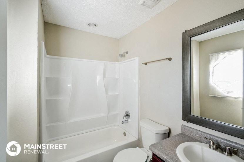 a bathroom with a white tub and a sink and a toilet