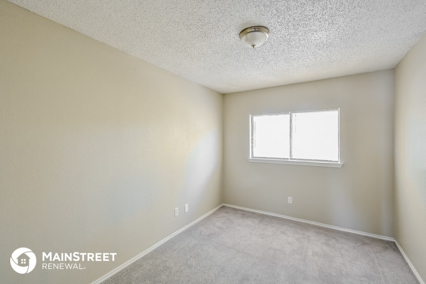 the spacious living room of an apartment with a window