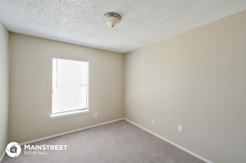 the interior of a small room with a window and carpet