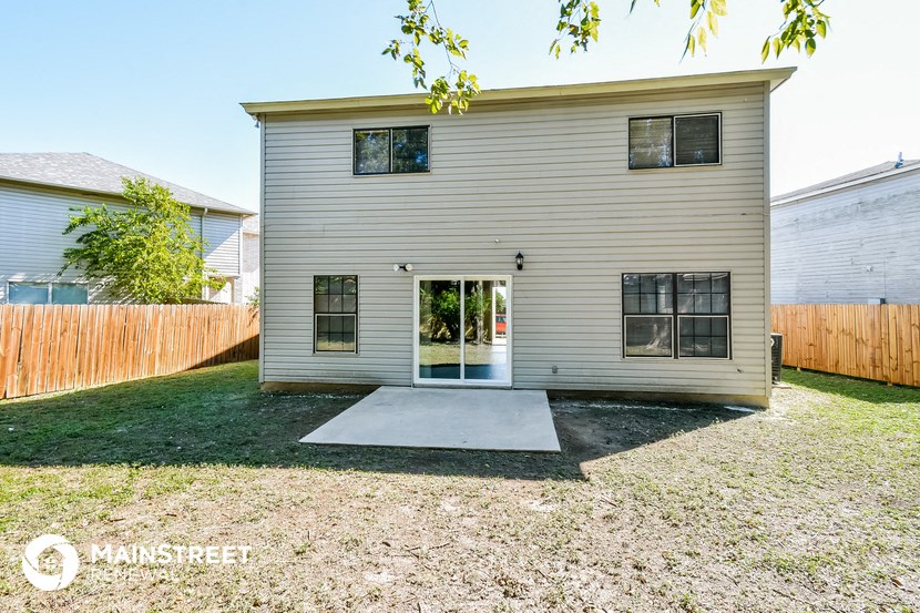 a small white house with a yard and a patio