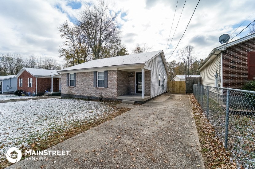 a small brick home with snow on the ground