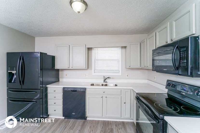 a kitchen with black appliances and white cabinets