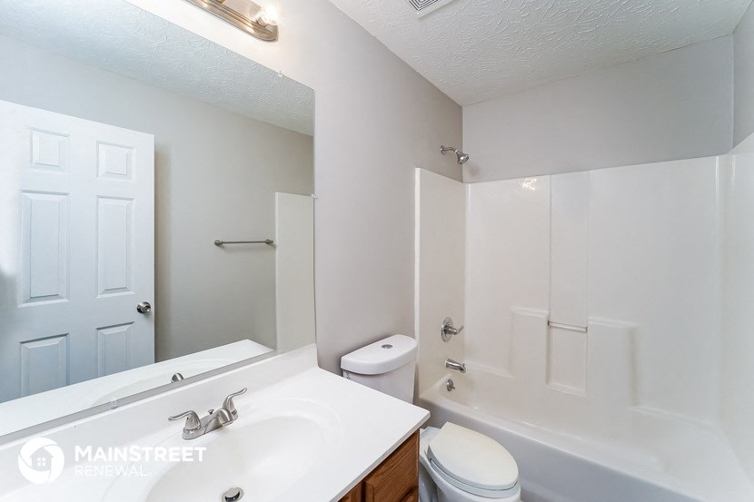 a bathroom with a white sink and a toilet and a shower