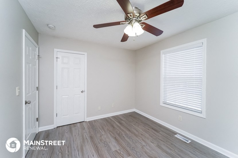 a bedroom with a ceiling fan and a white door