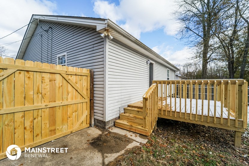 the backyard of a house with a wooden fence and a wooden deck
