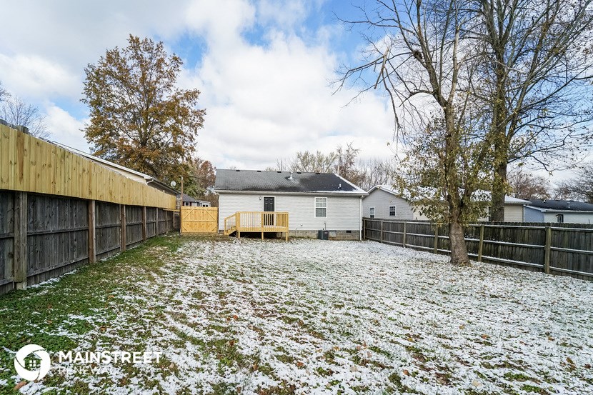 a backyard with a fence and a yard covered in snow