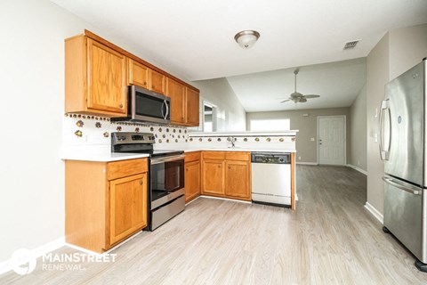 a kitchen with wooden cabinets and stainless steel appliances