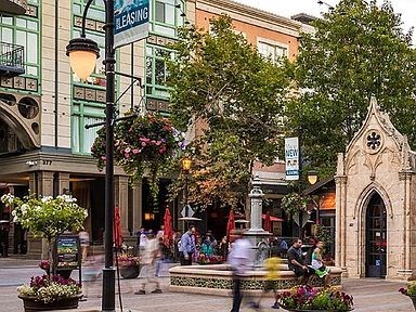 a busy city street with people and trees