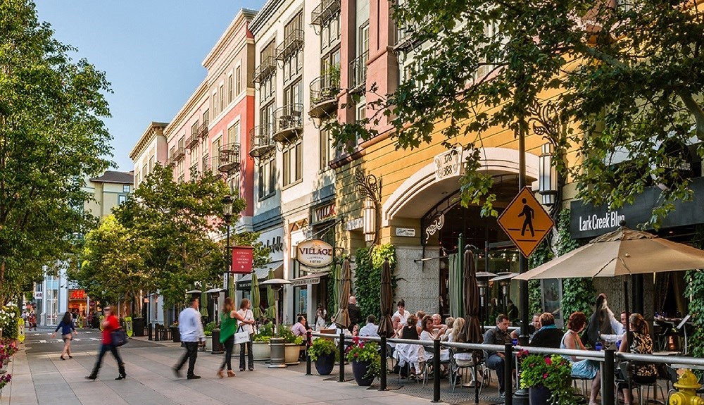 people walking down a street in front of buildings