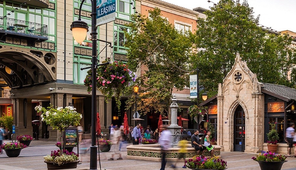 a city street with people walking and trees and buildings