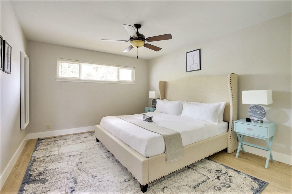 a bedroom with a bed and a ceiling fan