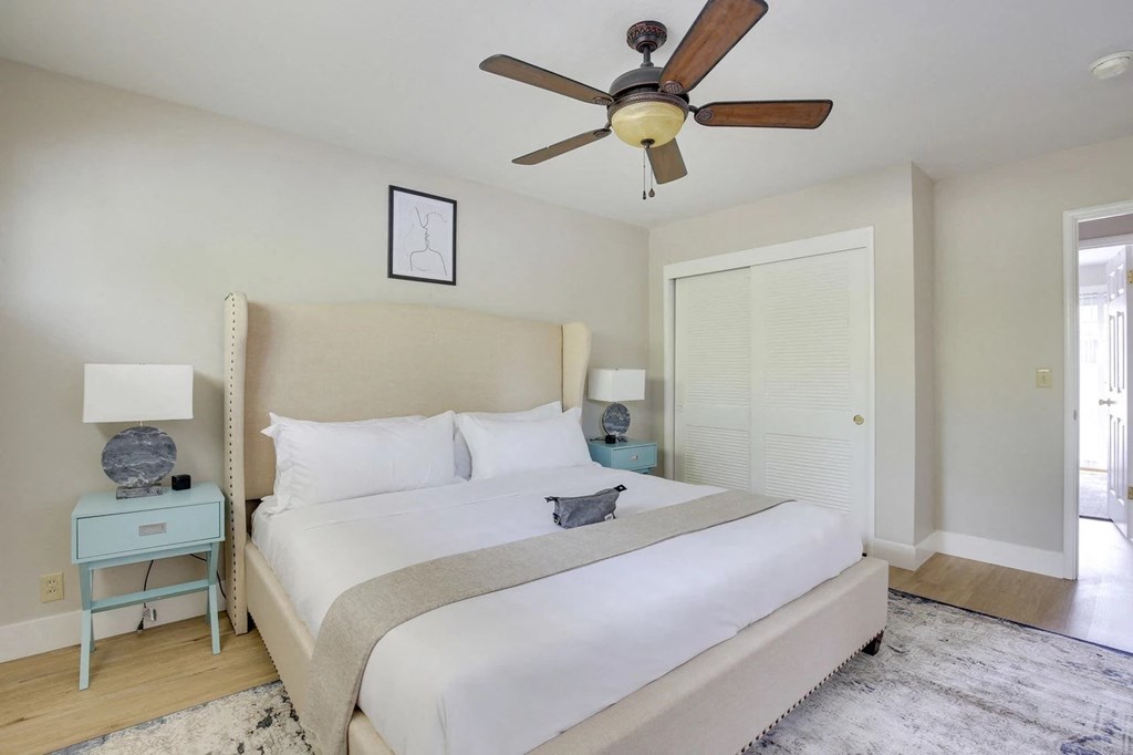 a bedroom with a large bed and a ceiling fan