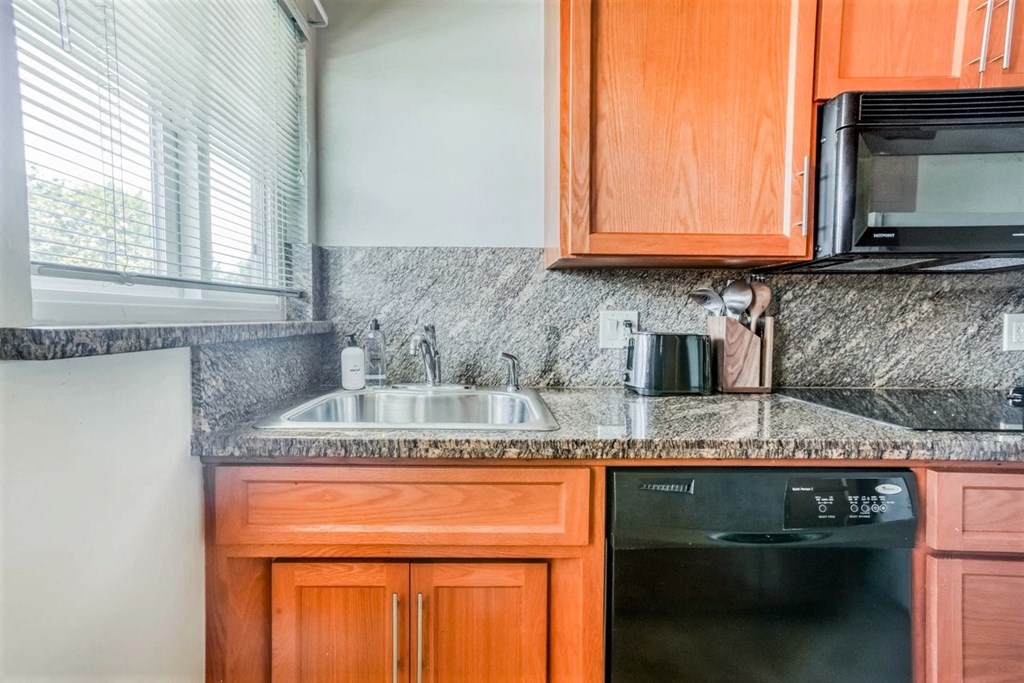 a kitchen with wooden cabinets and a sink and a window