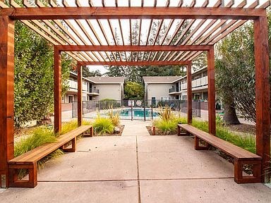 a covered area with benches and a swimming pool