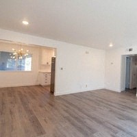 an empty living room with white walls and wood floors