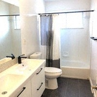 a bathroom with a toilet and a sink and a shower