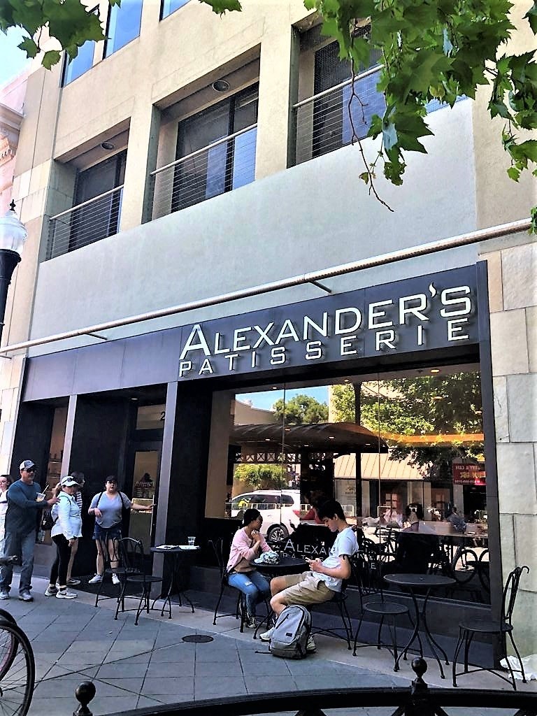 people are sitting at tables outside of a restaurant