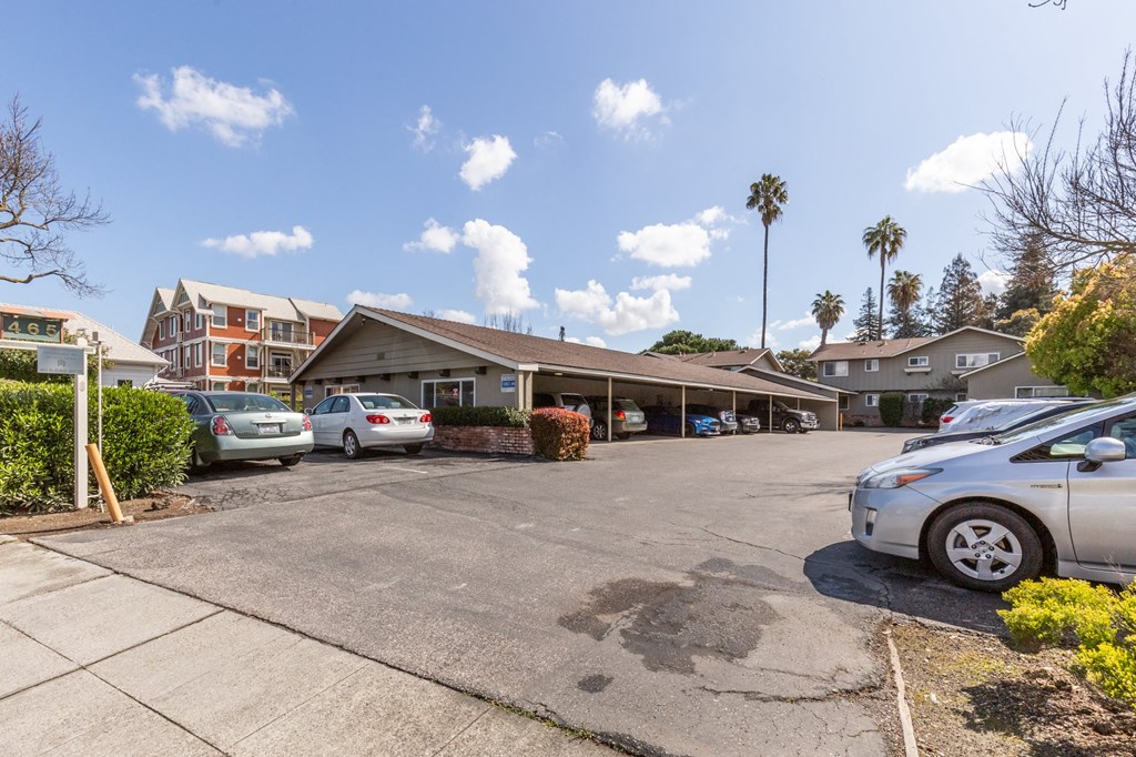 an empty parking lot with cars parked in front of a building