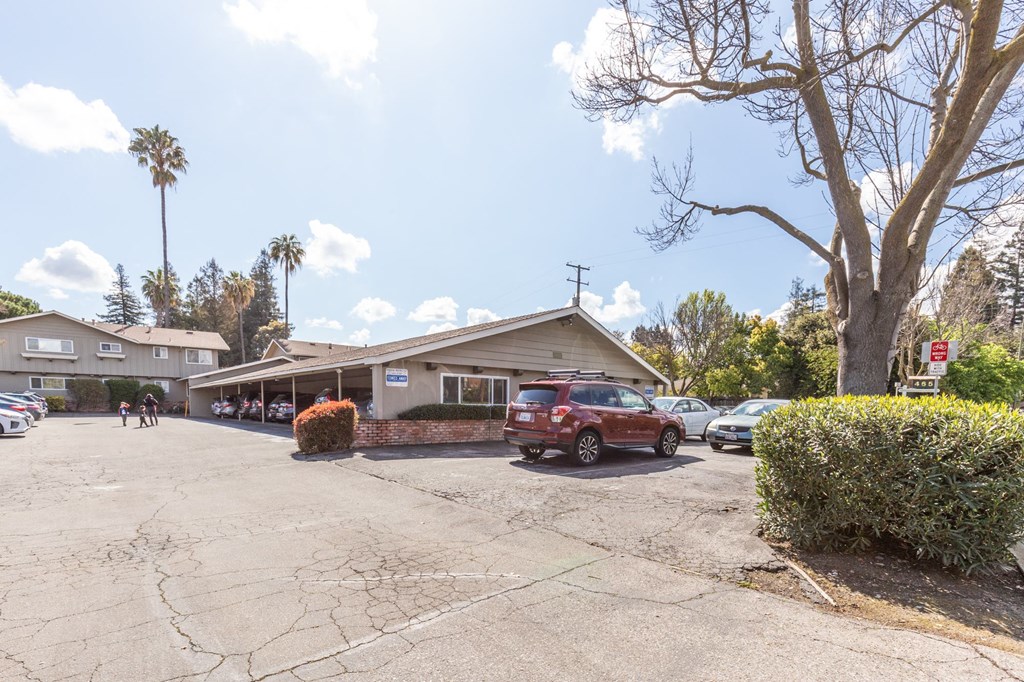 a parking lot in front of a building with cars parked in front
