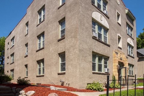 a large brick building with windows and a sidewalk in front of it