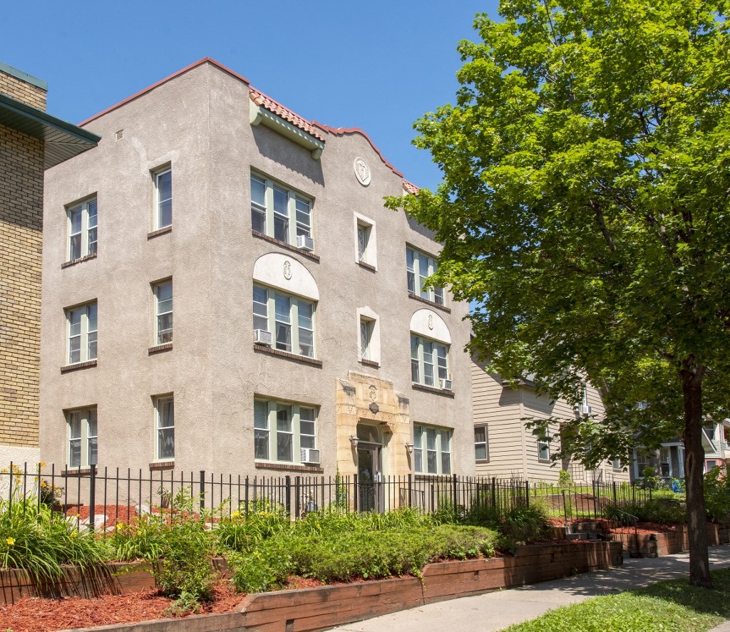 a large brick building with a tree in front of it