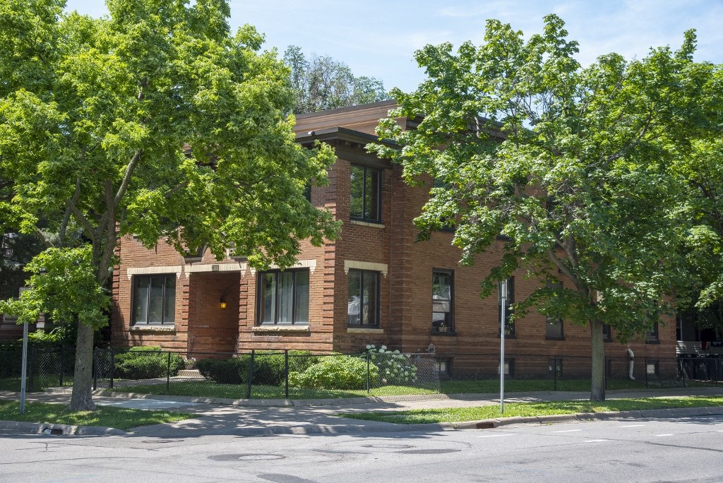 an old brick building with trees in front of it