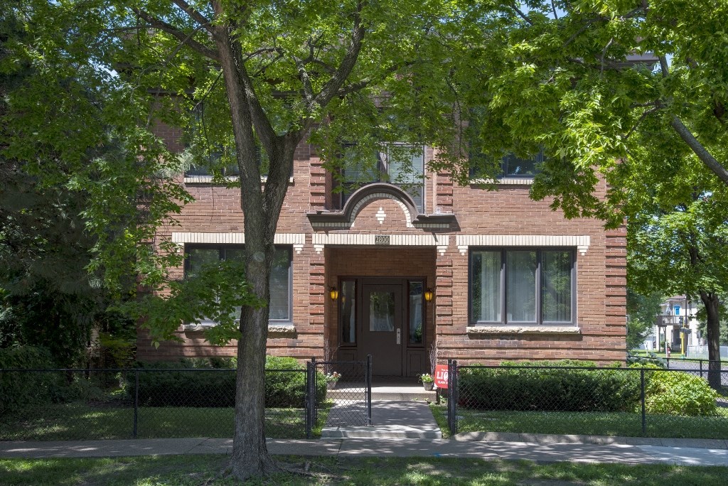 a brick house with a tree in front of it
