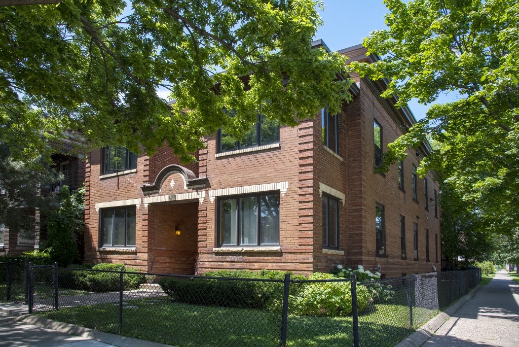 a brick building with a fence in front of it