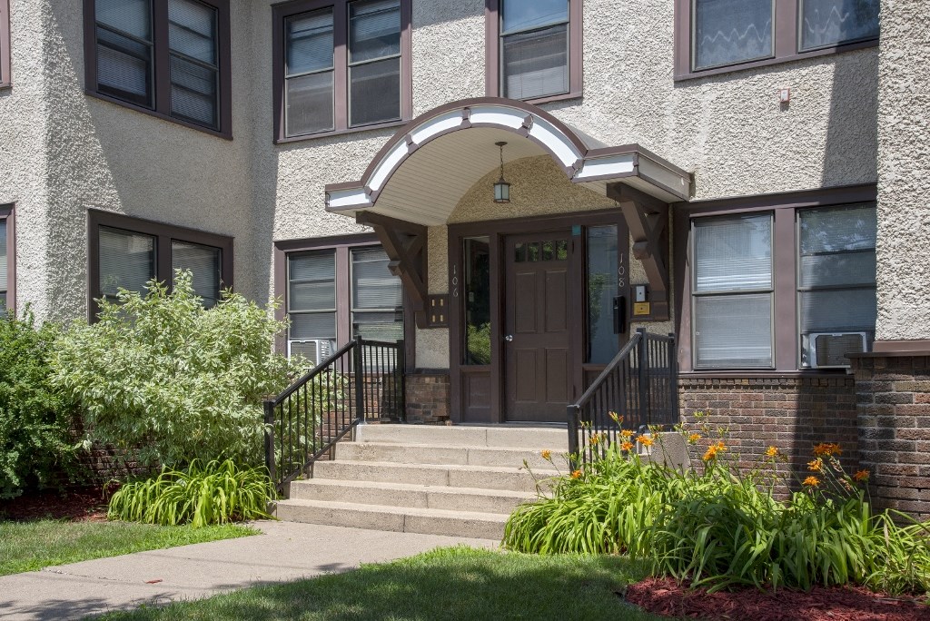the front of a building with stairs and a door