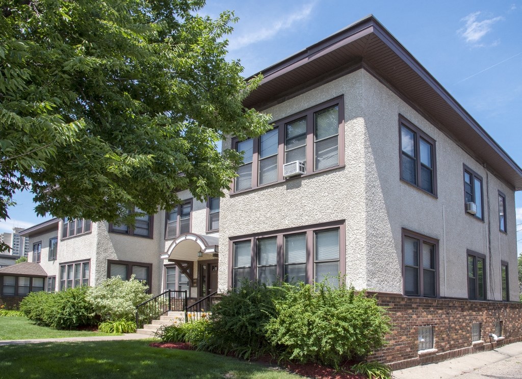 an apartment building with a tree in front of it