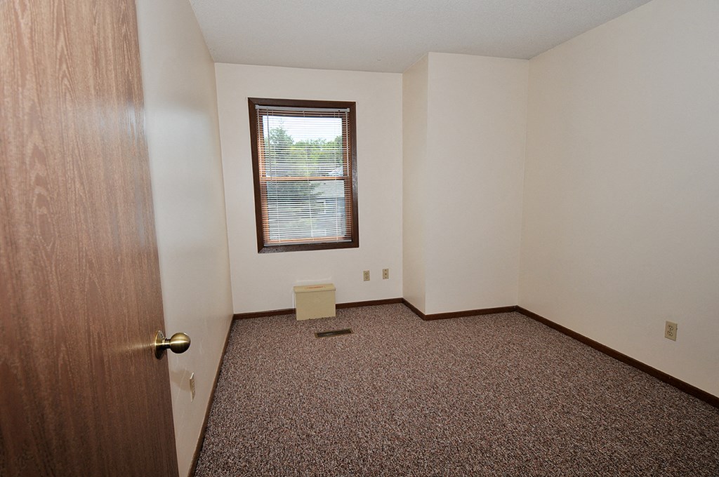 an empty room with a door and a window