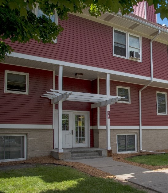 a red house with a white door and a porch