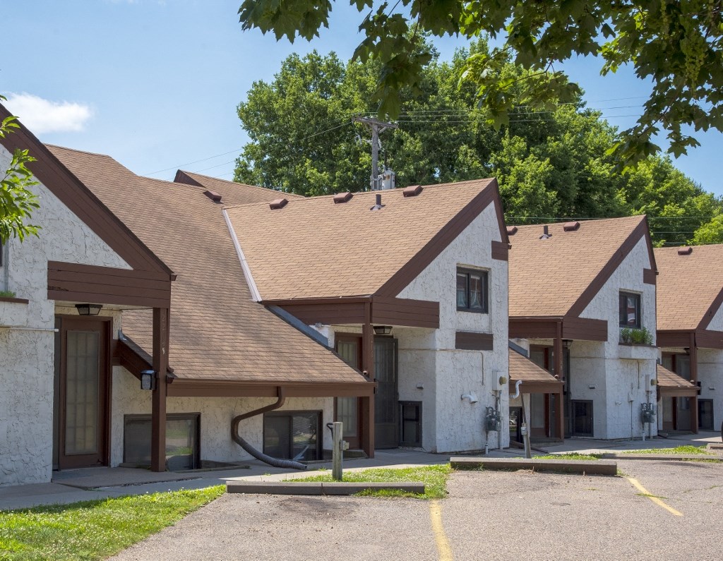 a group of houses with brown roofs and a parking lot