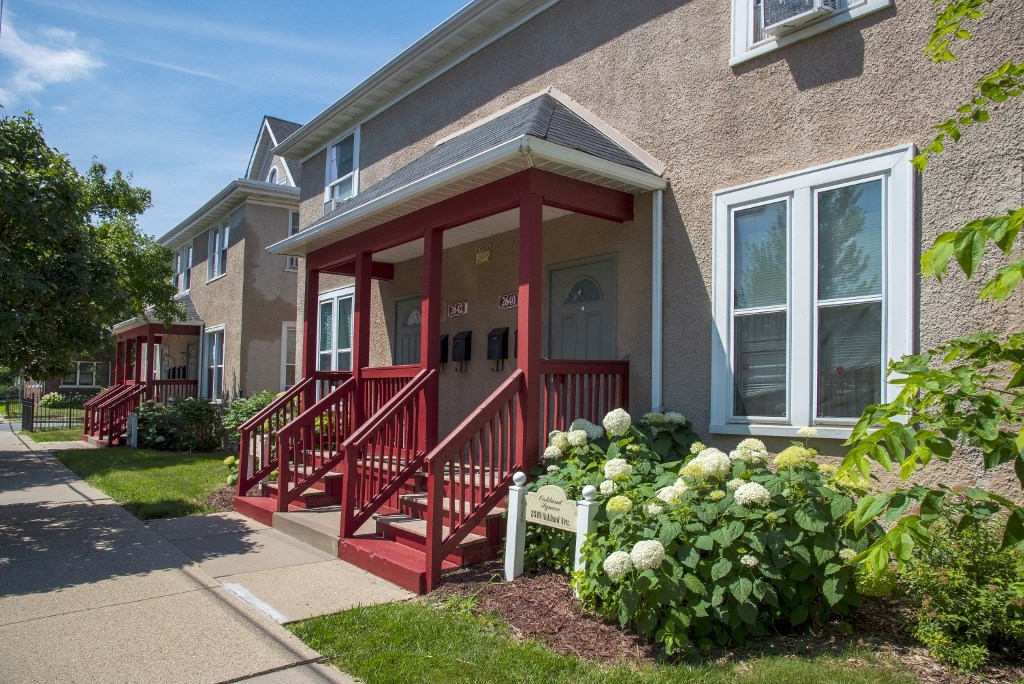 a red porch in front of a brick apartment building