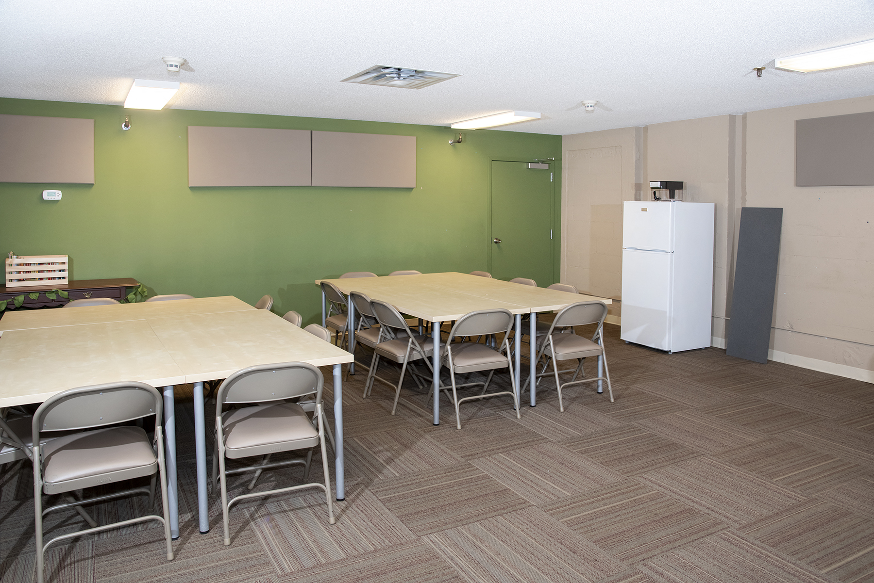 a dining room with tables and chairs and a refrigerator