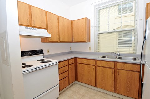 a kitchen with white appliances and wooden cabinets