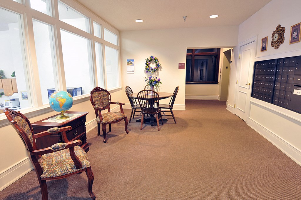 a dining room with a table and chairs and large windows