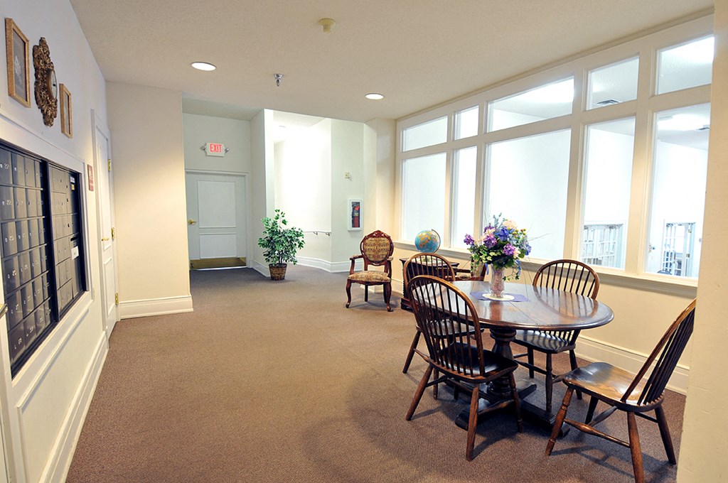 a dining room with a table and chairs and large windows