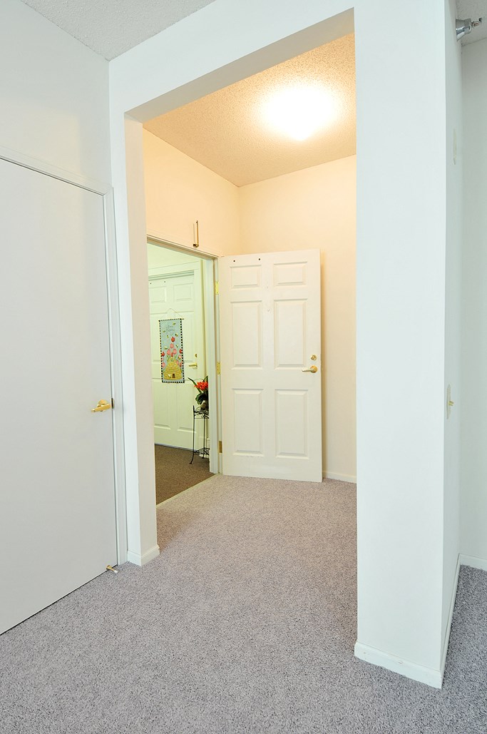 an empty room with a white door and a carpeted floor