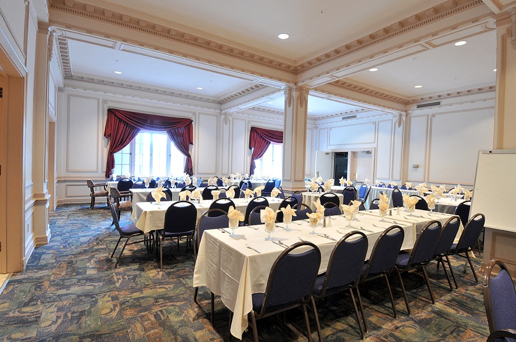a conference room filled with tables and chairs and a projection screen