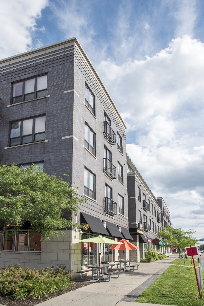 a tall building with a sidewalk in front of it