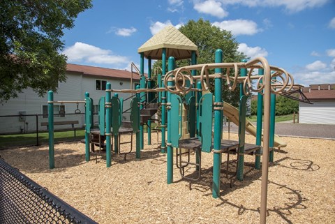 a playground at a park with a building in the background