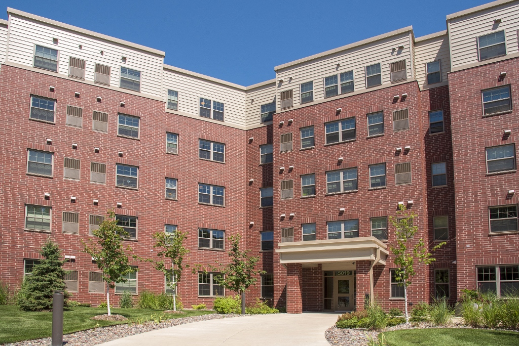 a large brick building with a sidewalk in front of it