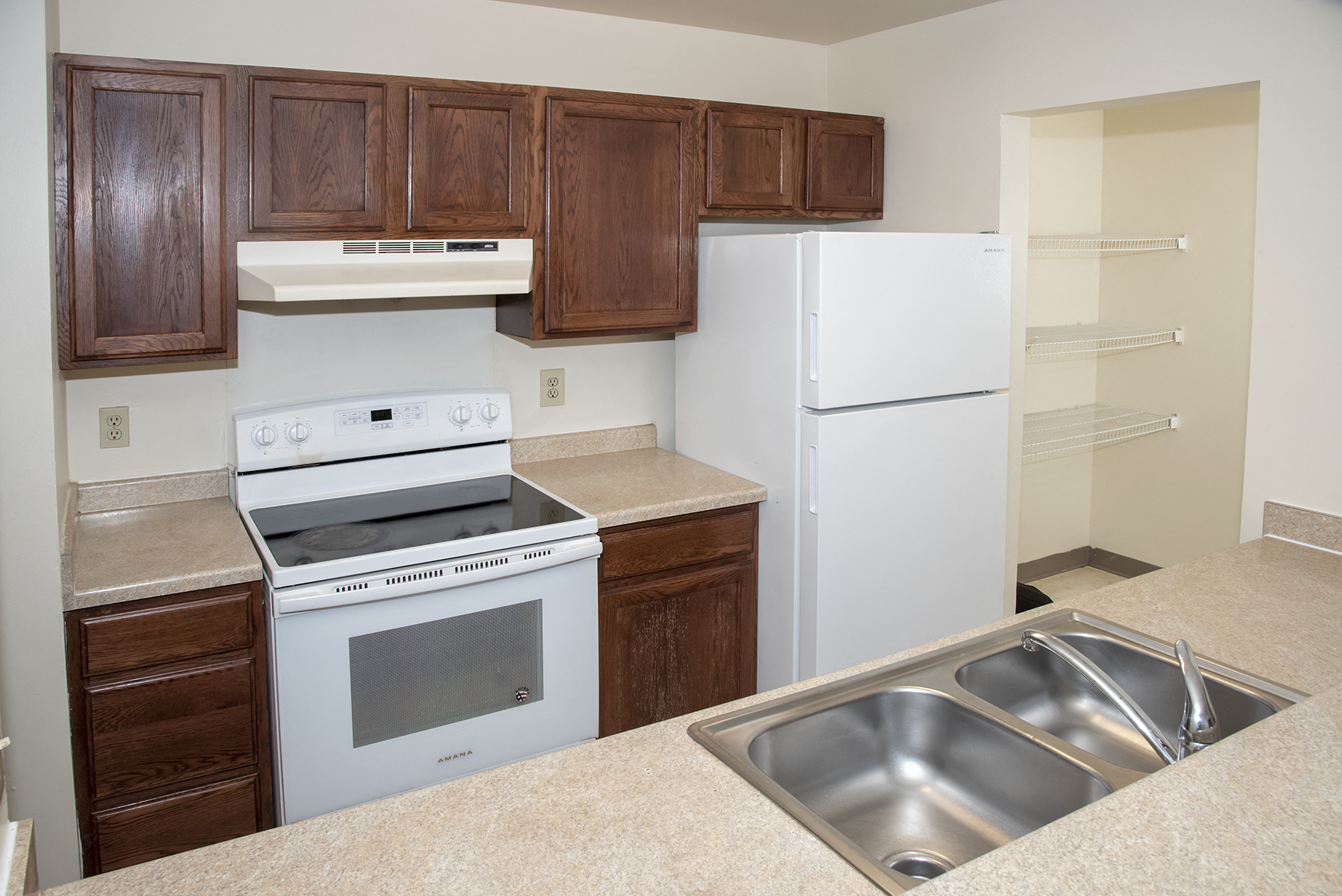 a kitchen with white appliances and wooden cabinets