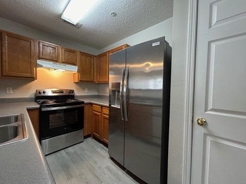 A kitchen with a stainless steel refrigerator and oven.
