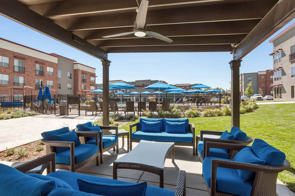 Westlake Greens Blue outdoor furniture and blue pool umbrellas in back