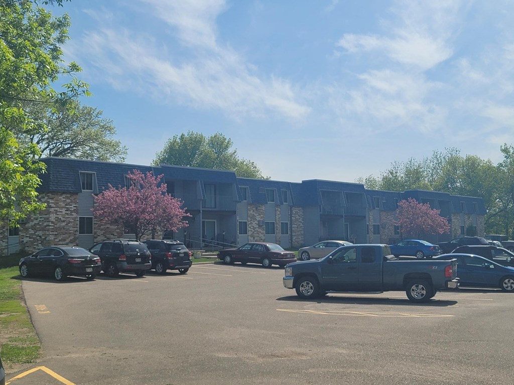 a parking lot with cars in front of a building
