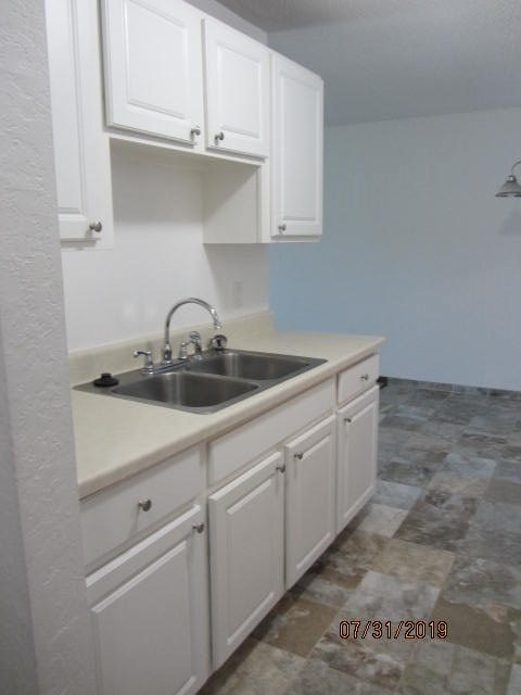 a kitchen with a sink and white cabinets