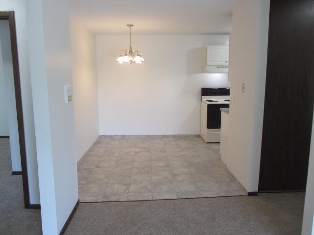 an empty living room with a kitchen in it