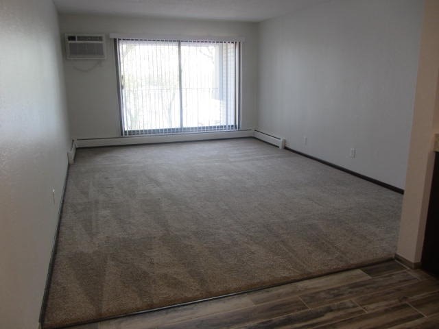 an empty room with a large window and a wooden floor